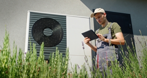 Technician,Using,A,Tablet,To,Inspect,An,Outdoor,Heat,Pump