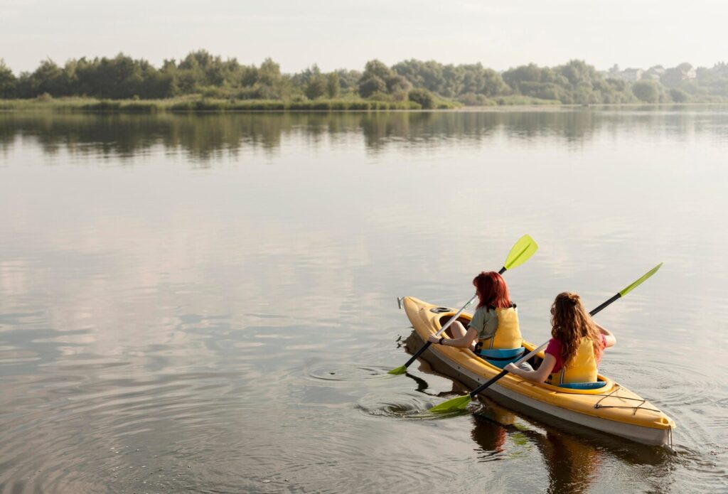 long-shot-women-rowing-kayak_23-2148683927